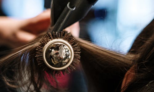 person combing out a woman's hair