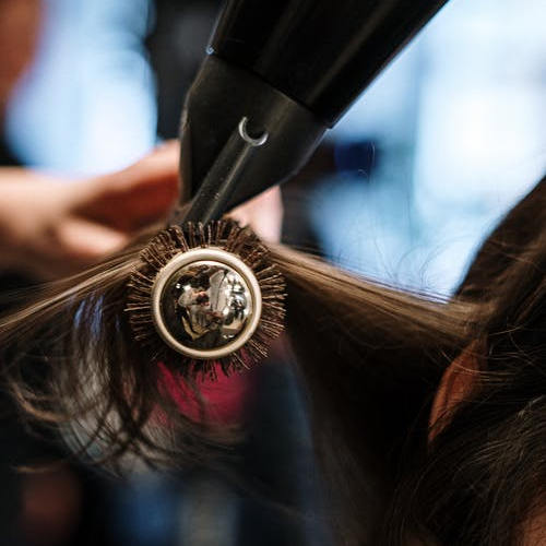 person combing out a woman's hair